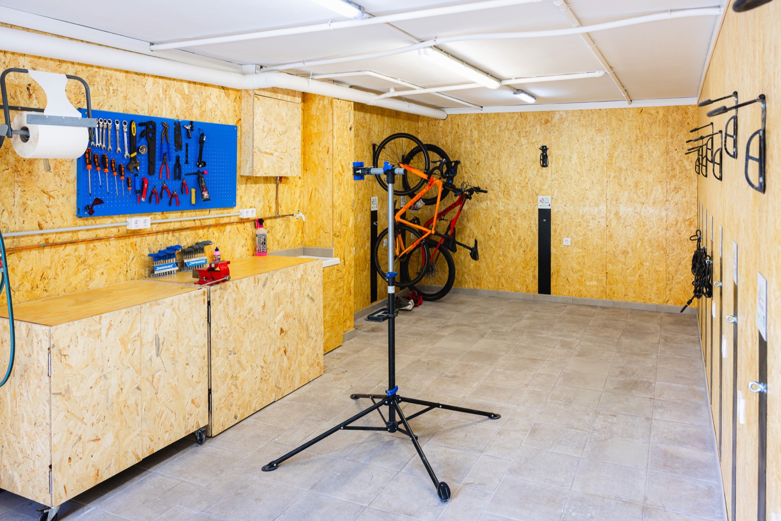 Garaje de bicicletas con ganchos y soporte de taller